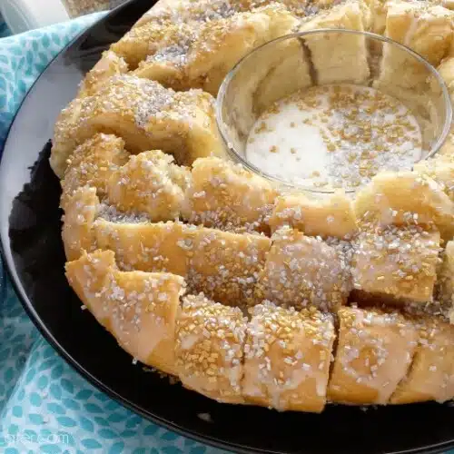 This New Year’s Party Loaf is filled with honey butter, topped with a powdered sugar glaze, and made to sparkle with edible silver and gold pearlized sugar sprinkles.