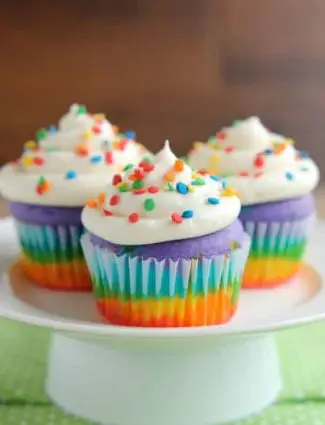 These Rainbow Cupcakes are made with a simple boxed white cake mix, colored, and layered to make a rainbow, with whipped cream cheese frosting on top! (Includes photo tutorial, and tips on baking cupcakes to perfection!)