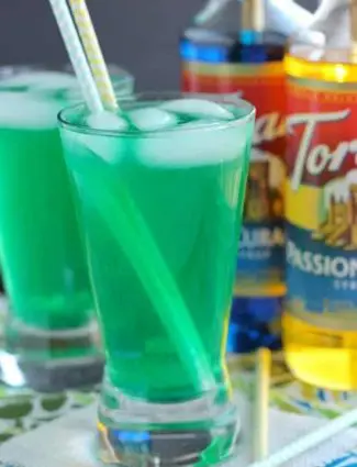 Xanadew - this FIIZ soda shop copycat drink recipe uses blue curacao and passion fruit syrups mixed into Mountain Dew for a fun green tropical mocktail!