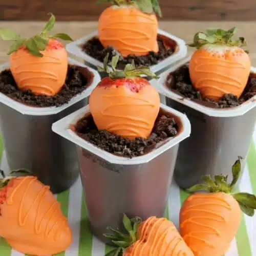 Carrot Easter Pudding Cups - These fun pudding cups are perfect for Spring and Easter with an orange candy dipped strawberry "carrot" in crushed Oreo and chocolate pudding "dirt."