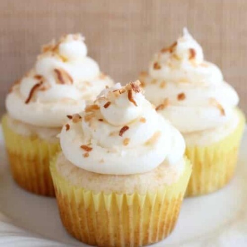 These Pina Colada Cupcakes have crushed pineapple in the cake, and coconut & rum extracts in the frosting, for a frozen drink inspired tropical dessert!