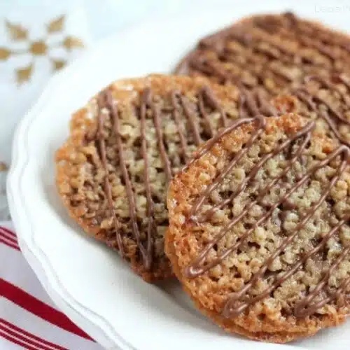 Thin, crisp, buttery cookies are sandwiched between melted milk chocolate with an extra chocolate drizzle on top. They taste like toffee and they look like lace. These Florentine Cookies are a holiday favorite!