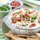 A loaded baked potato inspired this chip dip full of bacon, cheese, green onions, and ranch dressing mix. A delicious party dip or game day appetizer.