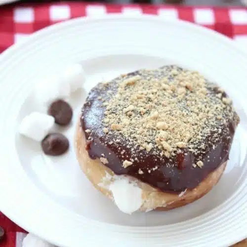 Glazed and ganached, with crushed graham crackers on top, and a marshmallow buttercream center, these S'mores Donuts are delicious and decadent.