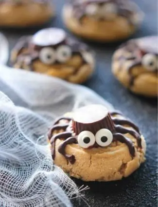 Not all Halloween food has to be gross and gory! These super cute spider cookies are made with peanut butter cups, chocolate, candy eyes, and the BEST peanut butter cookie recipe you'll ever try!