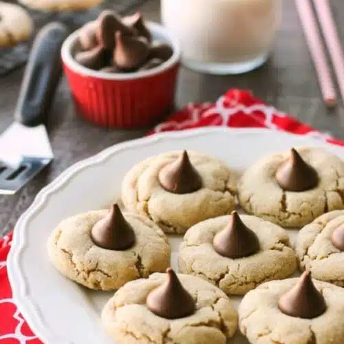 Peanut Butter Blossoms, Peanut Butter Kiss Cookies, and Peanut Butter Thumbprints are all one and the same. An easy and delicious soft peanut butter cookie with a large chocolate morsel center. Makes a great Christmas cookie to share with family and friends!