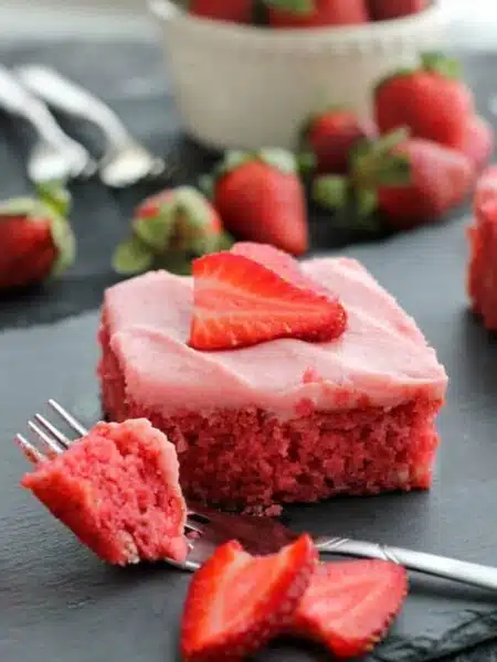 This strawberry cake uses fresh strawberries and flavored gelatin for a super flavorful strawberry sheet cake that will feed a crowd. It's really easy, and incredibly moist too!