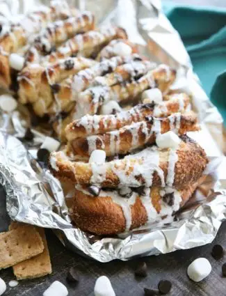 S'mores Pull Apart Bread is loaded with graham cracker crumbs, marshmallows, and chocolate chips, then topped off with a marshmallow glaze for a camping inspired dessert you can enjoy anytime!