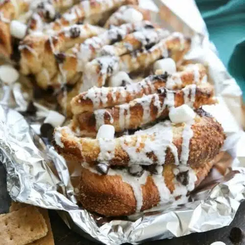 S'mores Pull Apart Bread is loaded with graham cracker crumbs, marshmallows, and chocolate chips, then topped off with a marshmallow glaze for a camping inspired dessert you can enjoy anytime!