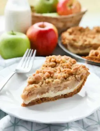 Apple Streusel Cheesecake Pie combines two dessert favorites with a graham cracker crust, creamy cheesecake layer, homemade apple pie filling, and crunchy streusel topping.