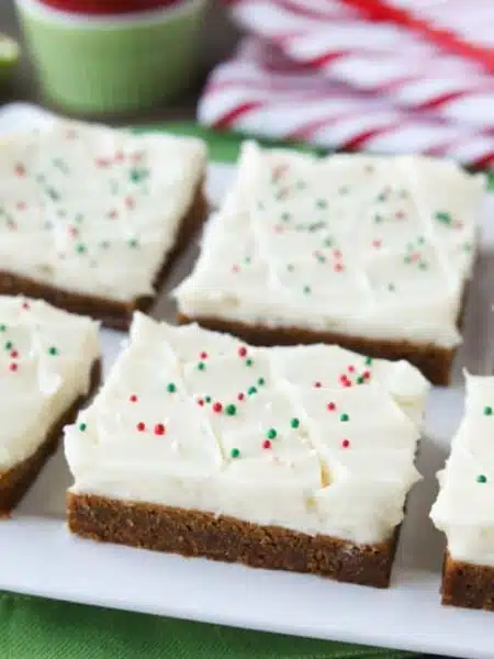 Gingerbread Cookie Bars have a soft and chewy, spiced molasses cookie base topped with the BEST cream cheese frosting. Add red and green sprinkles or nonpareils for a festive Christmas dessert!