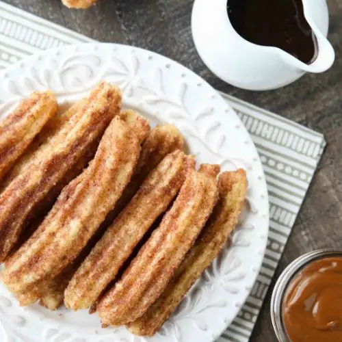 This churros recipe is super easy to make with a simple churro dough that is piped into oil and fried, then coated in cinnamon-sugar. You can enjoy these crisp, yet soft homemade churros anytime!