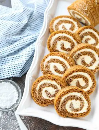 This classic Pumpkin Roll is a simple spiced pumpkin cake rolled up with the BEST cream cheese frosting inside. Use parchment paper for easy rolling -- no towel needed.