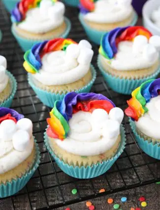 These Funfetti Rainbow Cupcakes are colorful inside and out! Homemade funfetti cupcakes are moist and full of sprinkles. Then topped with a colorful buttercream rainbow and mini marshmallow clouds. Super fun for birthday cupcakes or perfectly festive for St. Patrick's Day!