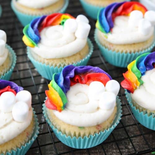 These Funfetti Rainbow Cupcakes are colorful inside and out! Homemade funfetti cupcakes are moist and full of sprinkles. Then topped with a colorful buttercream rainbow and mini marshmallow clouds. Super fun for birthday cupcakes or perfectly festive for St. Patrick's Day!