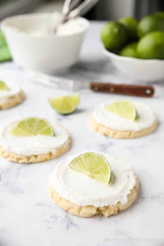 Coconut Lime Sugar Cookies - an easy sugar cookie recipe with a tropical fruit twist. You'll love these moist sugar cookies with a hint of lime, creamy coconut frosting, and a fresh lime wedge to squeeze on top. A Twisted Sugar copycat recipe.