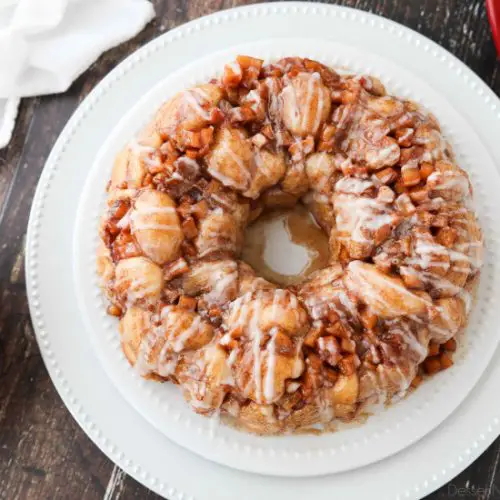 Apple Fritter Monkey Bread is an easy and delicious pull apart bread with chunks of caramelized apples, sticky cinnamon-sugar, and a light glaze. Fashioned after your favorite donut, this apple fritter bread makes a tasty breakfast or dessert.