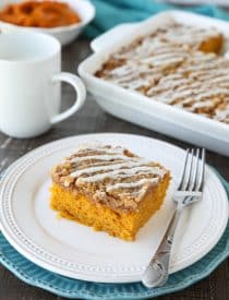 Pumpkin Spice Coffee Cake is easy to make and full of real pumpkin and fragrant spices. It's moist, yet light and fluffy, with a cinnamon crumb topping and pumpkin spice icing drizzled on top.