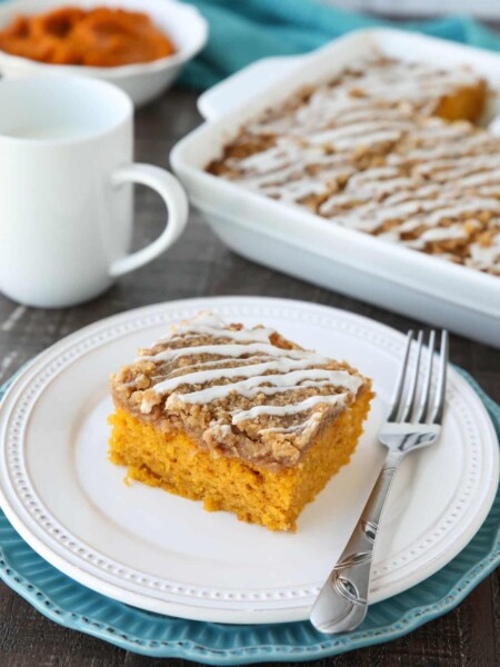 Pumpkin Spice Coffee Cake is easy to make and full of real pumpkin and fragrant spices. It's moist, yet light and fluffy, with a cinnamon crumb topping and pumpkin spice icing drizzled on top.