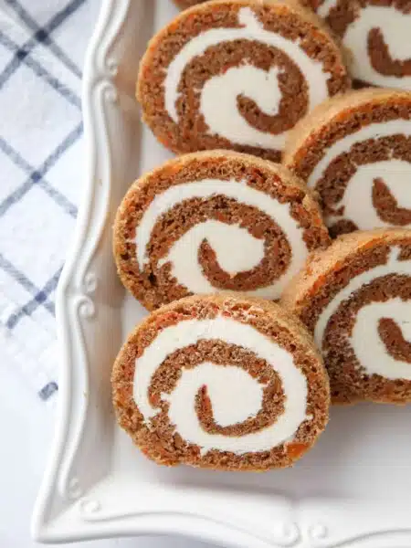 This Carrot Cake Roll is a classic Easter dessert with a twist. Spiced carrot cake is rolled up with the best cream cheese frosting inside. It's beautiful, delicious, and easy to make.