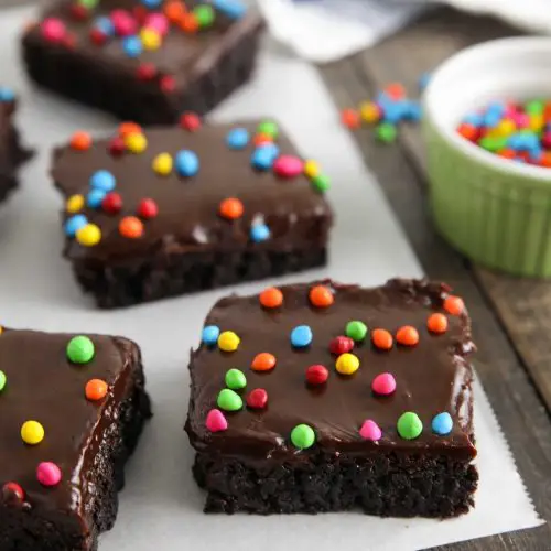 These homemade cosmic brownies are even better than store-bought! Rich, fudgy brownies are topped with a creamy chocolate ganache and candy coated chocolate chips. They're easy to make from scratch and not just for lunchbox treats!