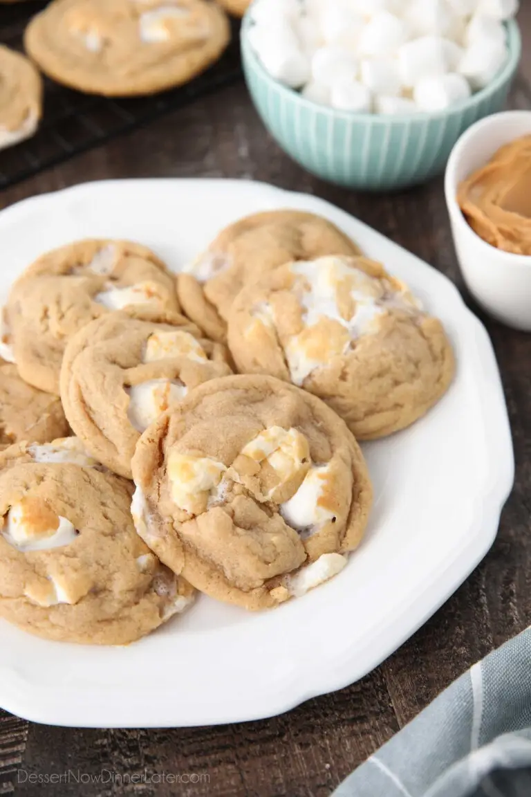 Fluffernutter cookies on a plate with bowls of mini marshmallows and peanut butter in the background.