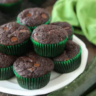 Plate full of chocolate zucchini muffins with chocolate chips.