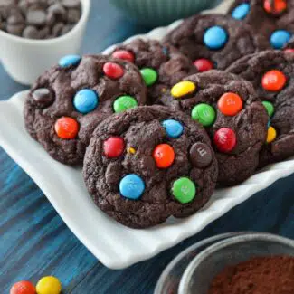 Chocolate cookies on a plate made with cocoa powder, chocolate chips and M&M's.