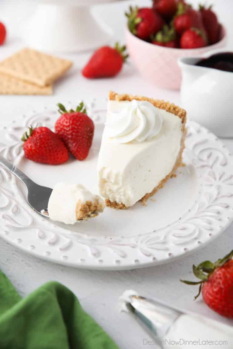 Slice of no bake cheesecake on a plate with a fork full.