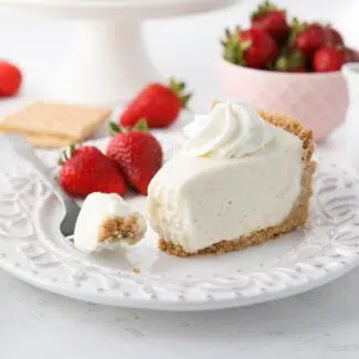 Slice of no bake cheesecake on a plate with a fork full.