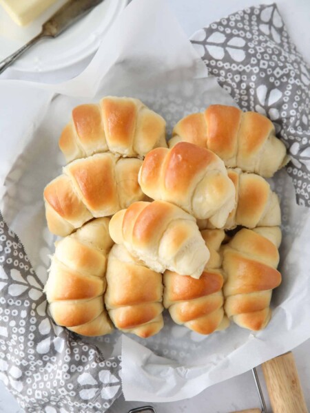 Fluffy homemade crescent rolls in a bread basket.