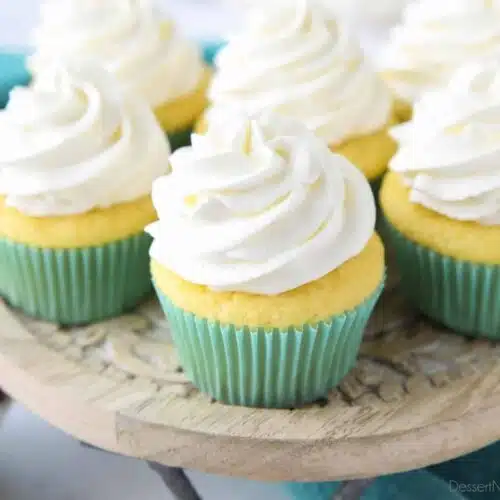 Zoomed in on cupcakes with whipped cream frosting piped high.