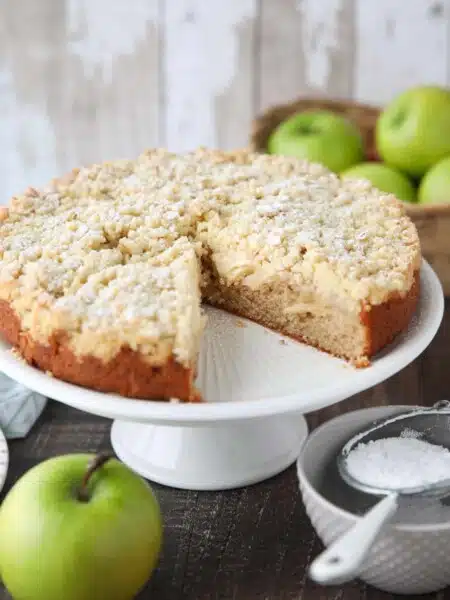 Cake platter with Irish apple cake and a slice taken out.