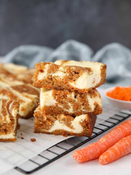 Carrot Cake Cheesecake Bars stacked on top of each other.