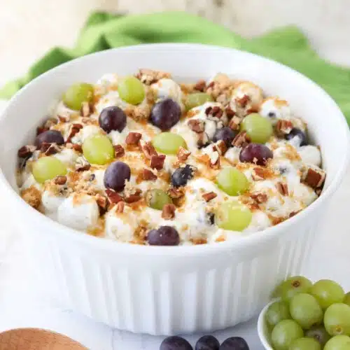 Large serving bowl full of grape salad.