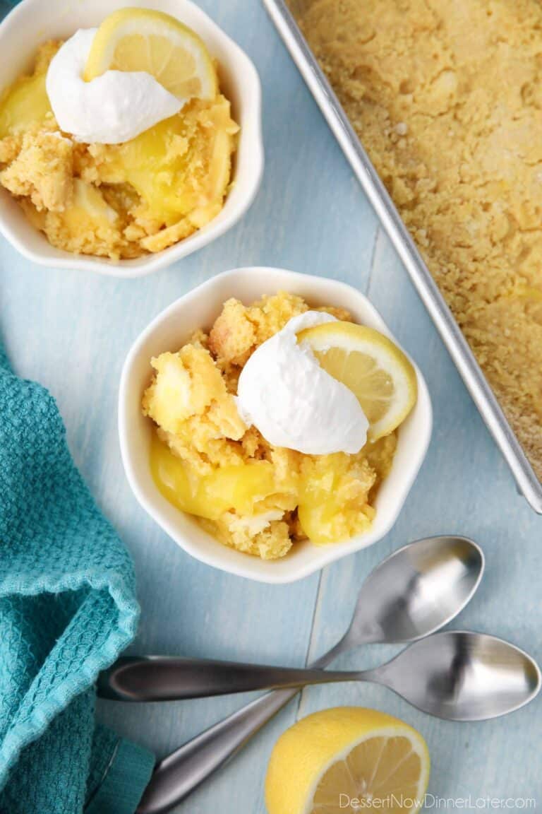 Lemon Dump Cake in a small bowl topped with whipped topping and a lemon slice.