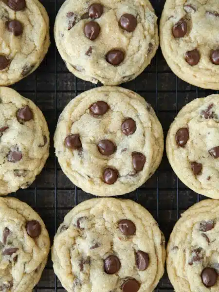 Baked chocolate chip cookies on wire cooling rack.