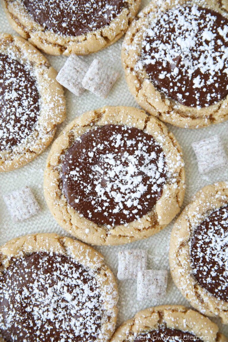 Close up of Muddy Buddy Cookies -- peanut butter cookies topped with melted chocolate and sprinkled with powdered sugar.