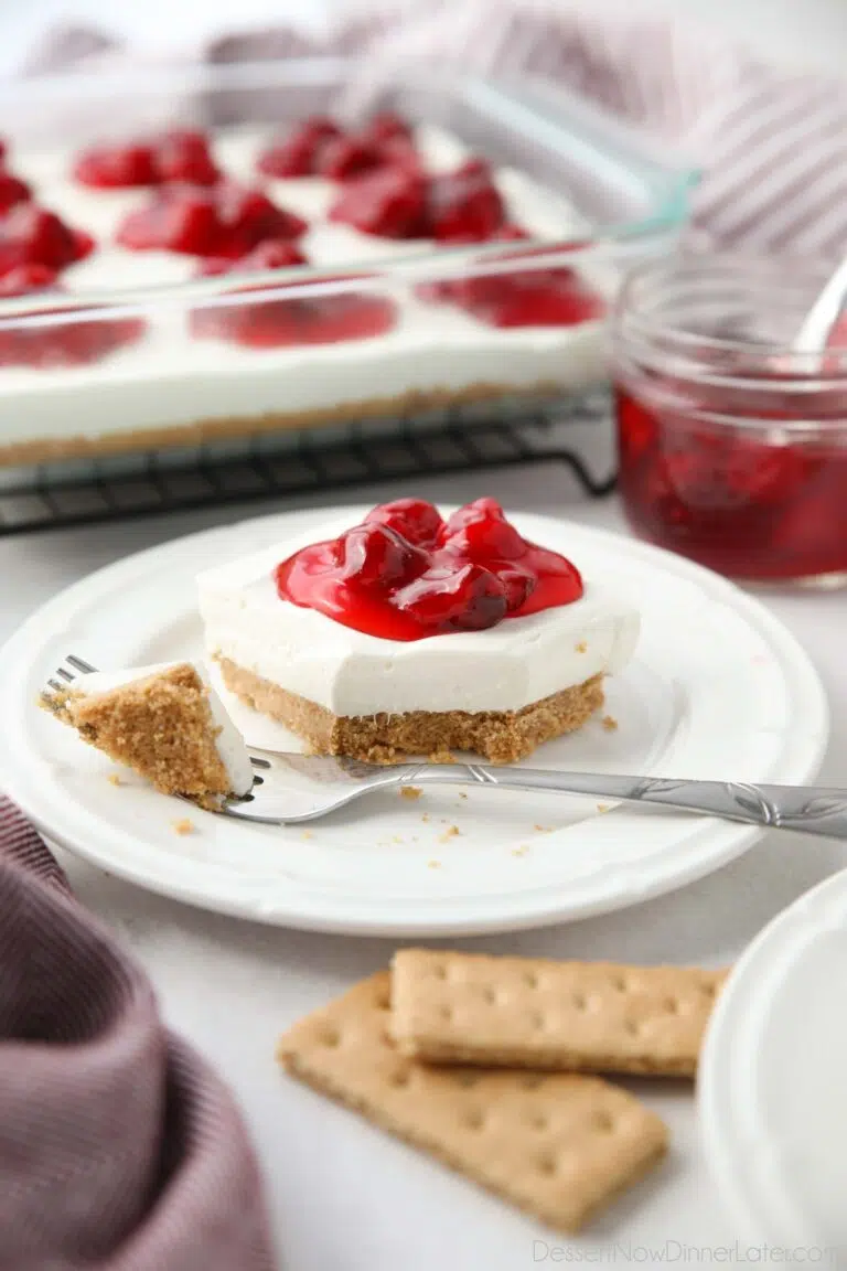 Slice of Cherry Delight on a plate with a fork-full taken out.