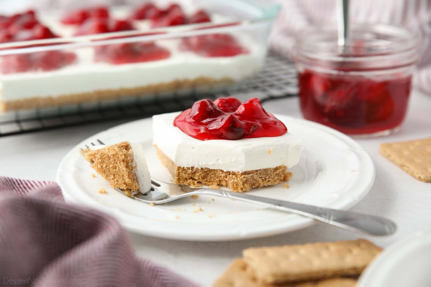 Slice of Cherry Delight on a plate with a fork full taken out.