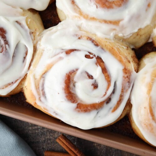 Close-up of the best cinnamon rolls with cream cheese frosting in pan.