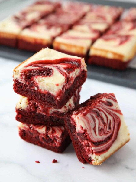 A stack of swirled Red Velvet Cheesecake Brownies.