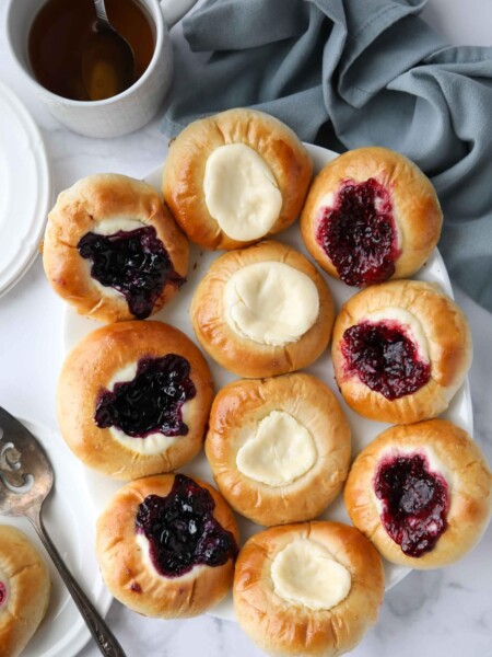 Variety of fruit and cream cheese kolaches on a platter.