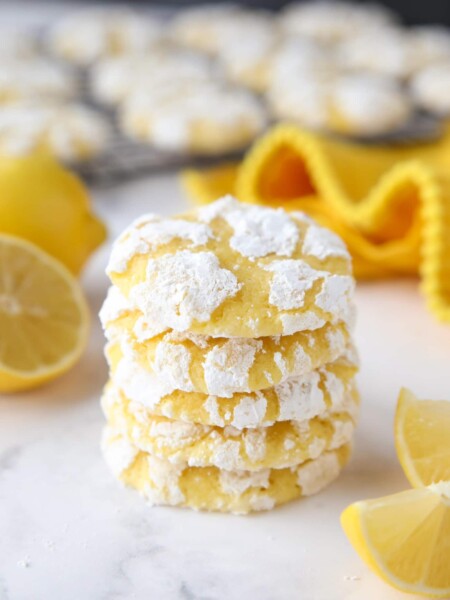 Stack of lemon crinkle cookies with powdered sugar on the outside.