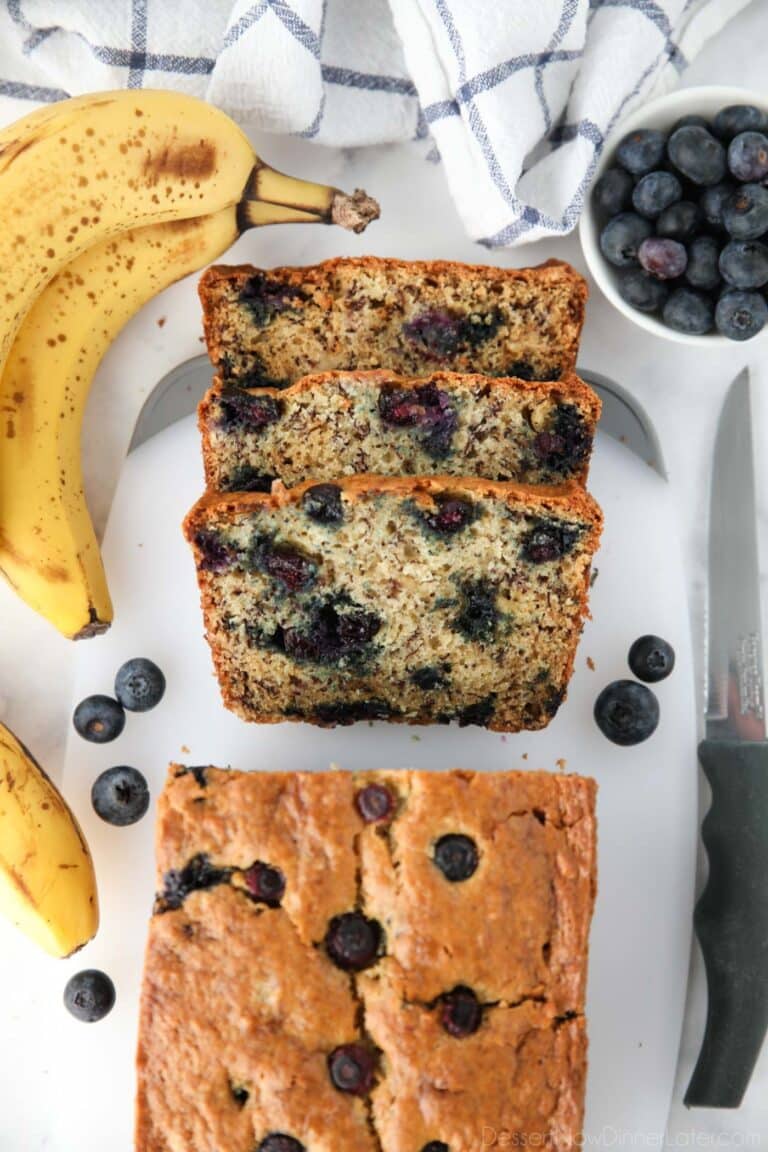 Blueberry banana bread with sour cream sliced on cutting board.