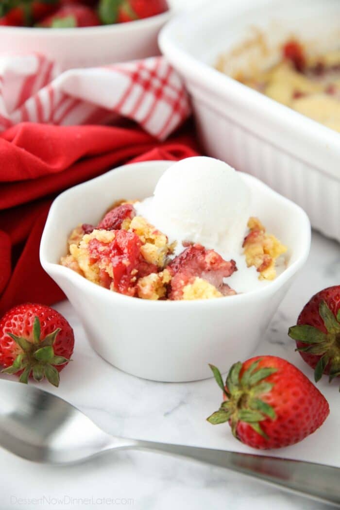 Bowl of strawberry dump cake with ice cream on top.