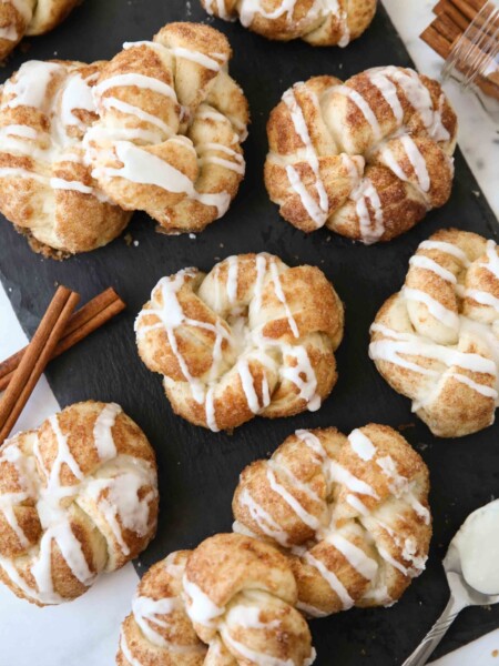 Iced cinnamon knots on a slate board.