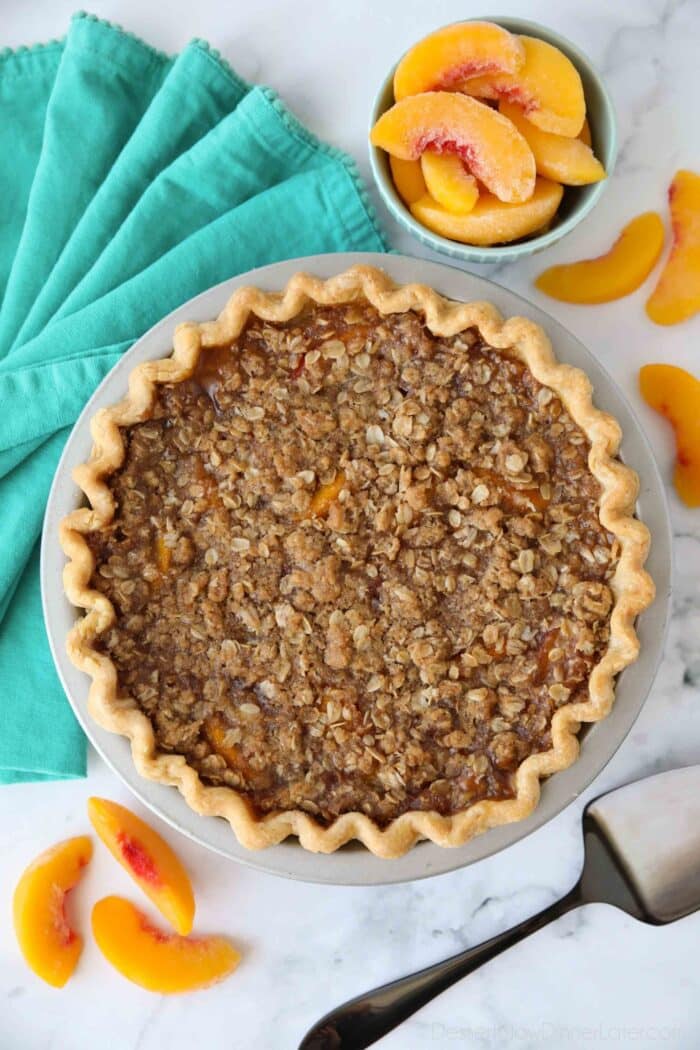 Top view of baked peach crumb pie in pan.