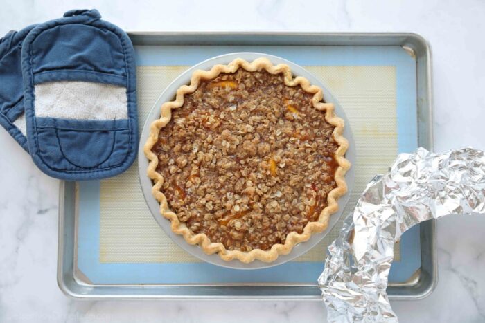 Freshly baked peach crumb pie straight out of the oven.