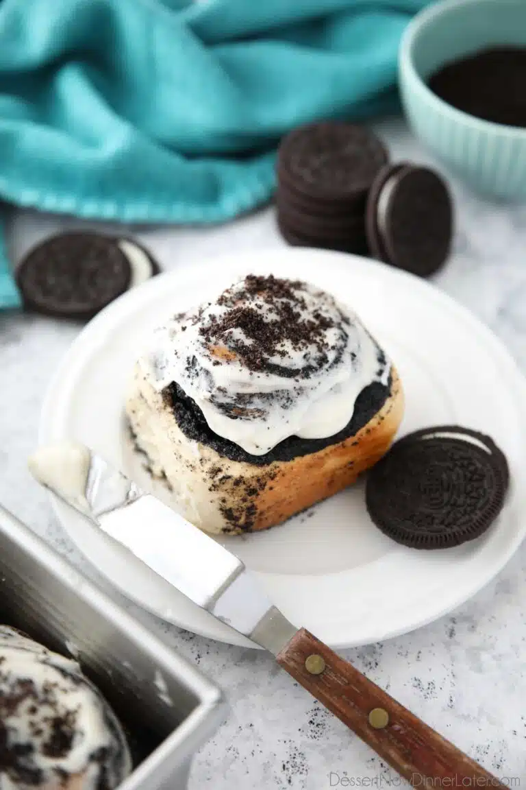 Top view of an Oreo cinnamon roll with cream cheese frosting on a plate.